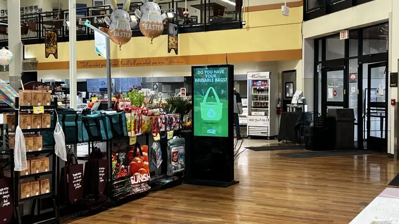 Digital signage displaying reusable bag information inside Sunset Foods